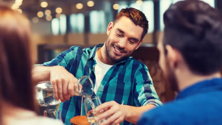 man at restaurant pouring water